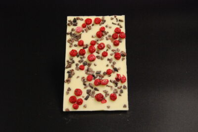 Tafel aus weißer Schokolade bestreut mit Kakaonibs und getrockneten Johannisbeeren