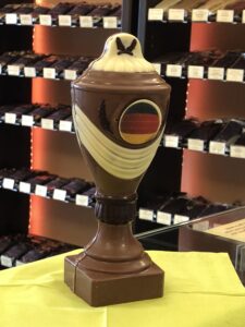 Schokoladenpokal aus Vollmilchschokolade mit Deko aus weißer Schokolade und Zartbitter-Schokolade und mit Deutschland Flagge