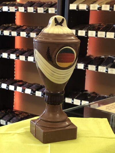 Schokoladenpokal aus Vollmilchschokolade mit Deko aus weißer Schokolade und Zartbitter-Schokolade und mit Deutschland Flagge