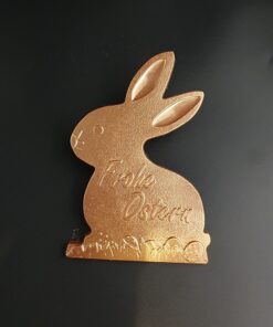 Hasenförmige Tafel aus Vollmilch-Schokolade mit Schriftzug "Frohe Ostern" und Bronze-Pulver