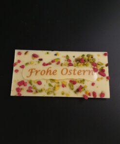 Mini Ostertafel aus weißer Schokolade mit kristallisierten Rosen, gehackten Pistazien und Aufschrift "Frohe Ostern"