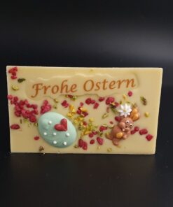 Ostertafel aus weißer Schokolade mit Lebensmittelfarbe, Zuckerdekor, gehackten Pistazien und kristallisierten Rosen