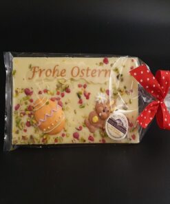 Ostertafel aus weißer Schokolade mit Lebensmittelfarbe, Zuckerdekor, gehackten Pistazien und kristallisierten Rosen, Geschenkverpackung
