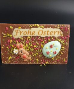 Vollmilchschoko-Ostertafel mit bunter Zuckerdekor, kristallisierten Rosenblüten und gehackten Pistazien und Schriftzug Frohe Ostern