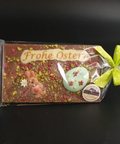 Ostertafel aus Vollmilch-Schokolade mit Zuckerdekor, kristallisierten Rosenblüten und gehackten Pistazien, verpackt
