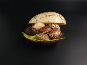 Schokoladen-Ei aus verschiedenen Schokoladen, gefüllt mit 6 Pralinen-Ostereiern